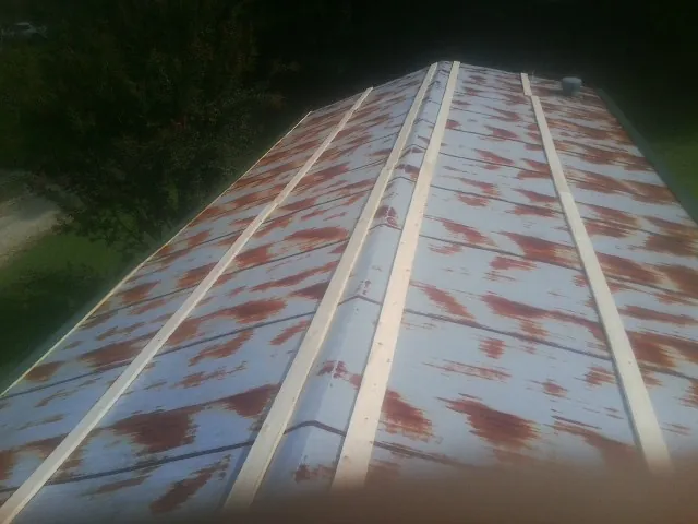 Rusted metal roof panels with new wood purlins before replacement — Storm Damage Roof Repair in Modoc by Roofing Brothers