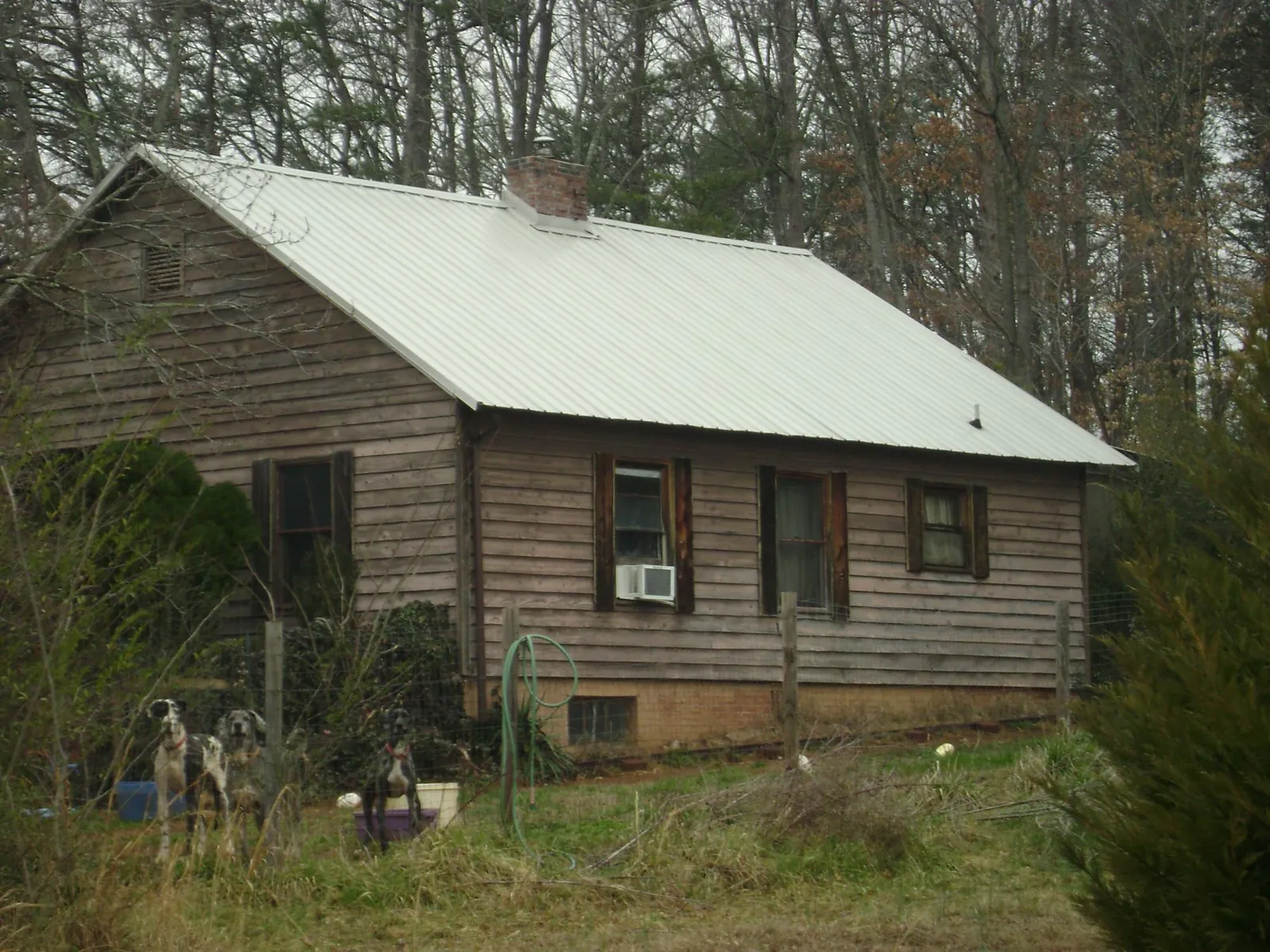 White metal roof on an old wood sided farmhouse, from a Metal Roof Installation job in Modoc